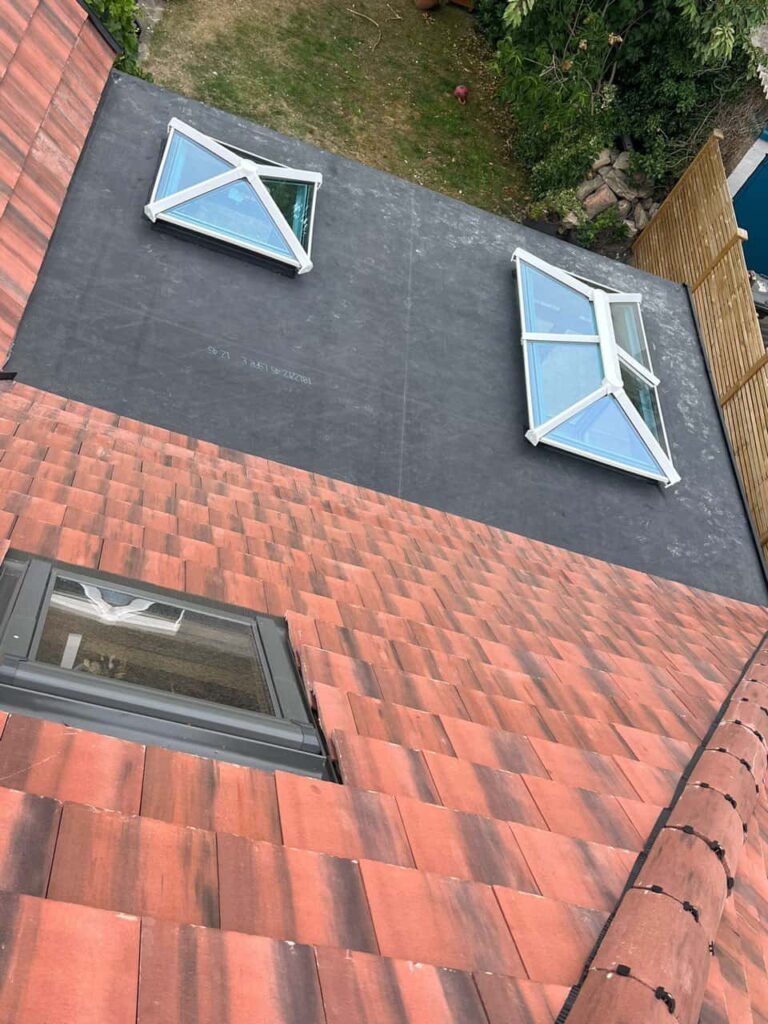 This is a photo taken from the roof ridge looking down a tiled pitched roof on to a flat roof. Works carried out by LJ Roofing Haydon Wick